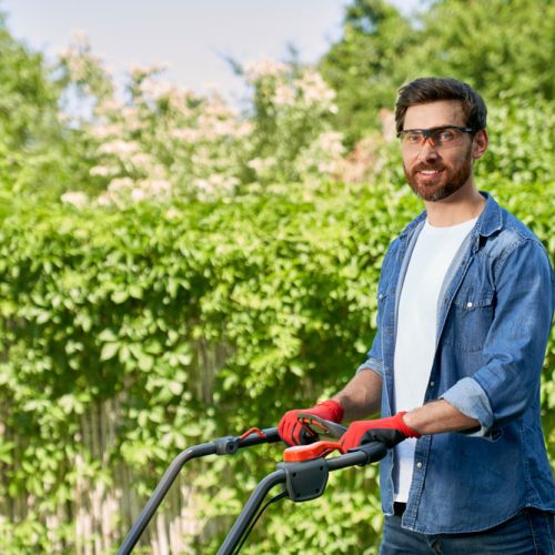smiling-gardener-shirt-mowing-lawn-with-modern-lawn-mower-summer-season-side-view-brunet-(1)